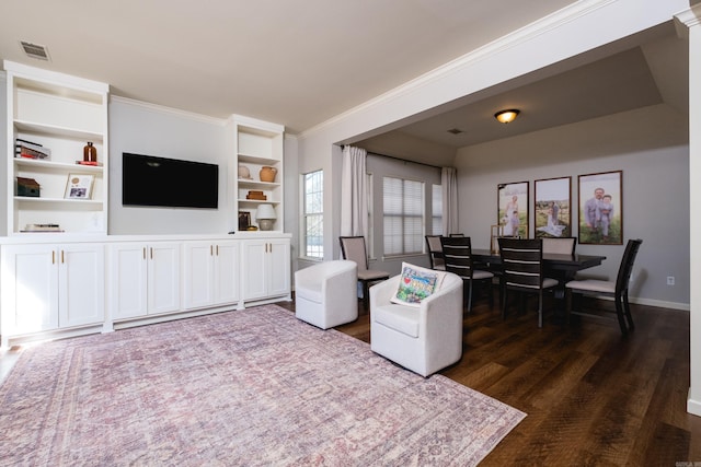 living room featuring built in features, baseboards, visible vents, ornamental molding, and dark wood-type flooring