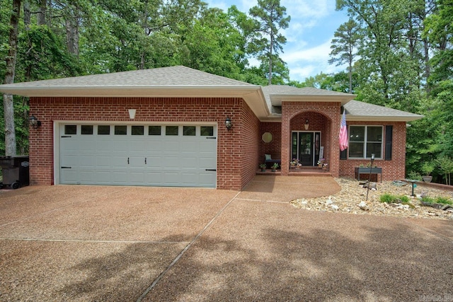 ranch-style house with a garage, driveway, brick siding, and roof with shingles