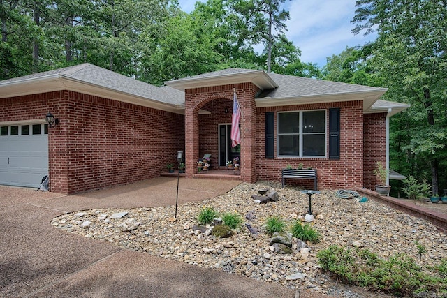 ranch-style house featuring brick siding, roof with shingles, and an attached garage