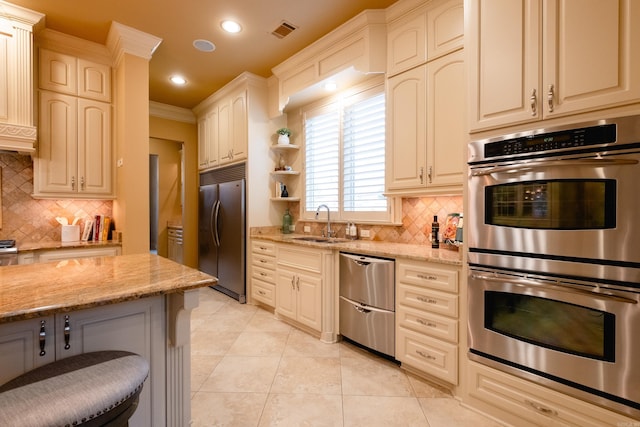 kitchen with light tile patterned floors, light stone counters, stainless steel appliances, a sink, and visible vents