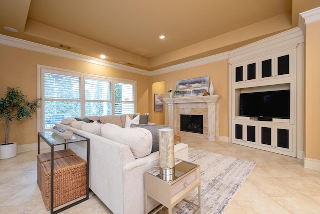 tiled living room featuring baseboards, a fireplace, ornamental molding, and a raised ceiling