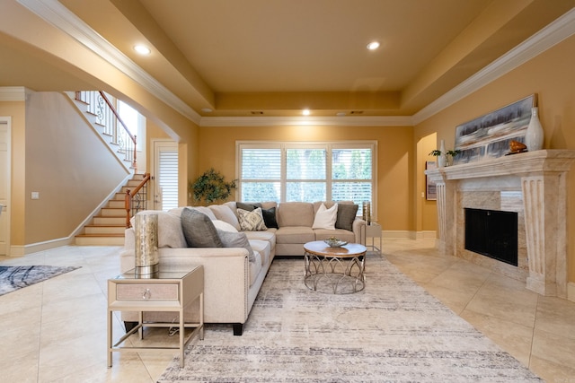 living room featuring stairs, a tray ceiling, ornamental molding, and a fireplace