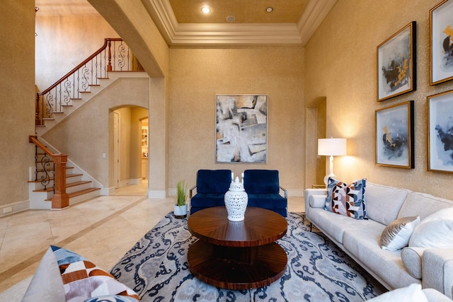 living room with ornamental molding, arched walkways, a towering ceiling, and baseboards