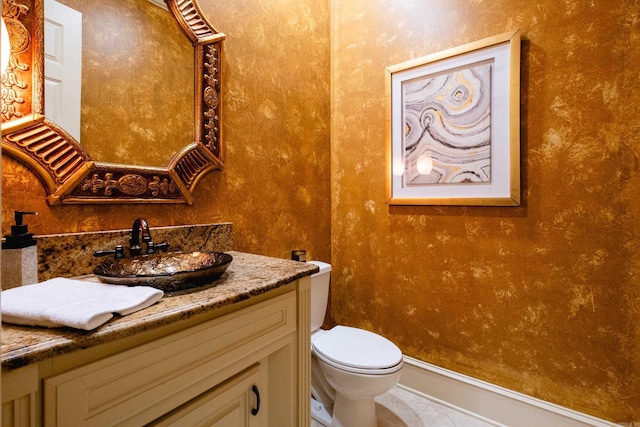 bathroom with toilet, tile patterned floors, and vanity