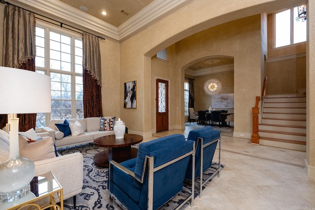 living area featuring arched walkways, crown molding, stairway, a towering ceiling, and baseboards