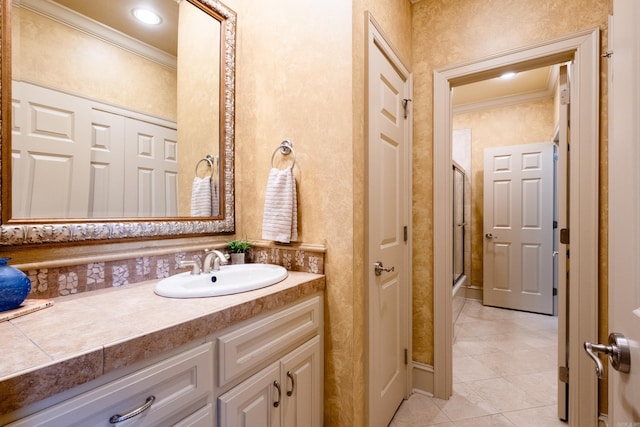 bathroom with tile patterned floors, vanity, a shower with shower door, and crown molding