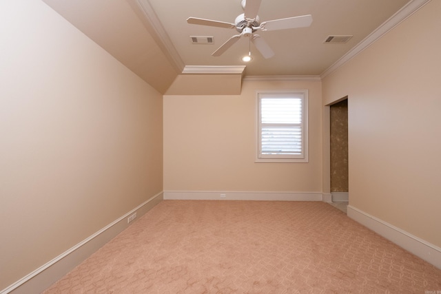 carpeted spare room with ornamental molding, visible vents, baseboards, and a ceiling fan