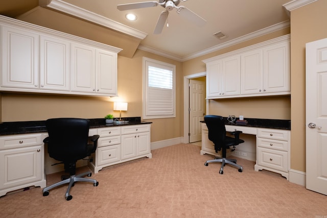 office space with light colored carpet, visible vents, baseboards, built in study area, and crown molding