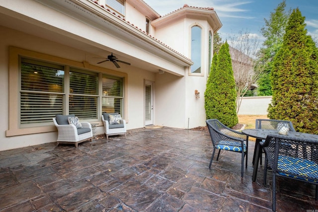 view of patio / terrace with ceiling fan, fence, and outdoor dining area