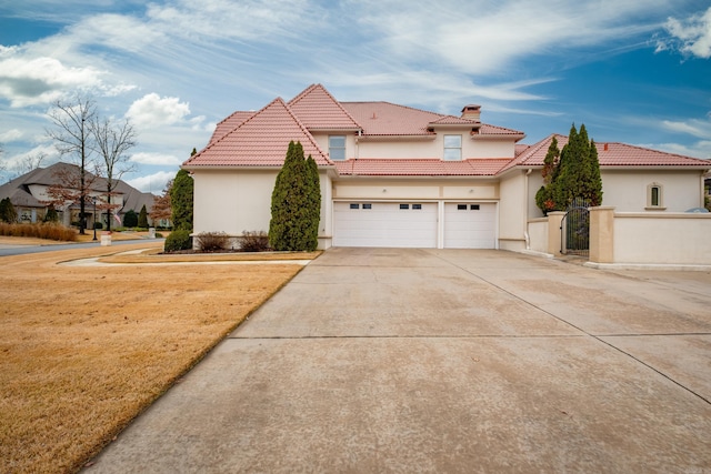 view of front of property with a tiled roof, fence, driveway, and stucco siding