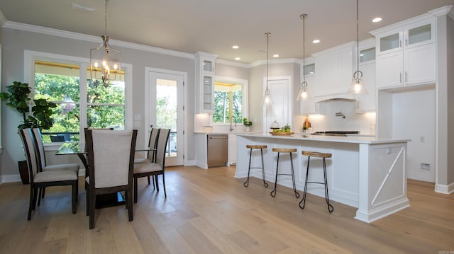 kitchen with dishwasher, light countertops, a kitchen island, and white cabinetry