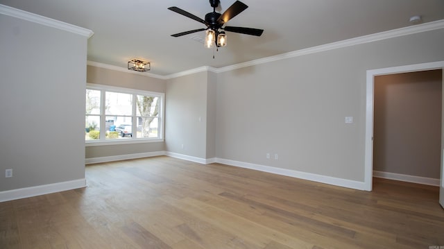 empty room featuring ornamental molding, baseboards, and wood finished floors