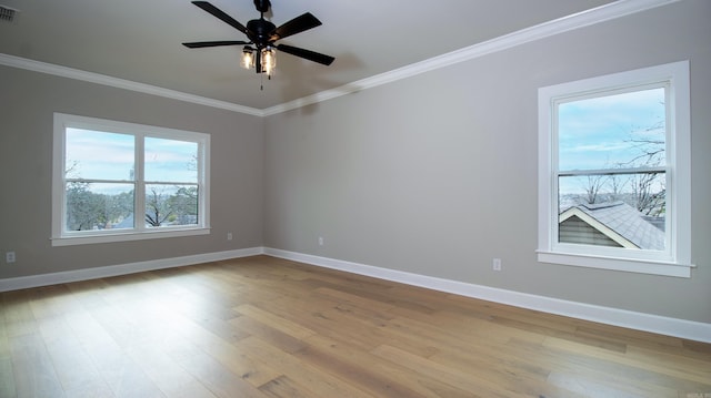 unfurnished room with baseboards, visible vents, crown molding, and wood finished floors