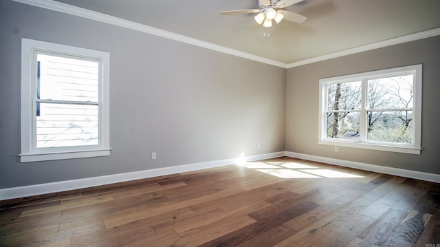 empty room with baseboards, ornamental molding, and hardwood / wood-style floors