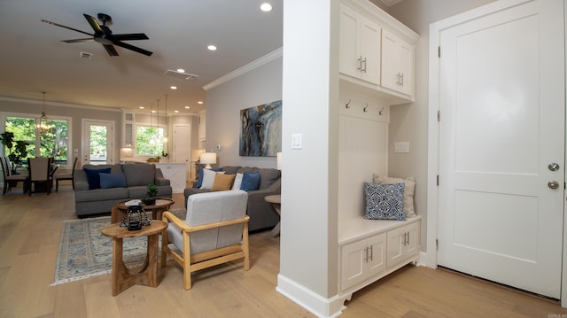 living area with visible vents, ornamental molding, light wood-style flooring, and recessed lighting