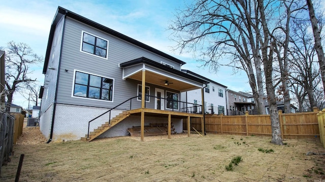 back of property with central air condition unit, a fenced backyard, stairway, and brick siding