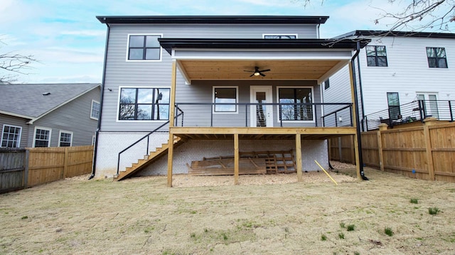 back of property with ceiling fan, stairway, fence private yard, a wooden deck, and brick siding