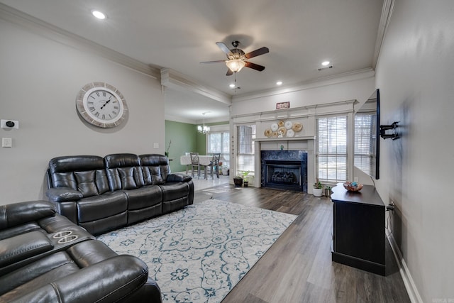 living area featuring ornamental molding, wood finished floors, a high end fireplace, and baseboards