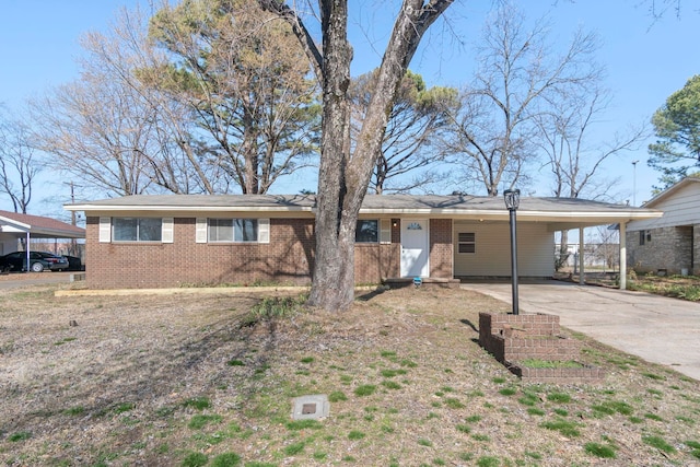 ranch-style house featuring an attached carport, concrete driveway, and brick siding