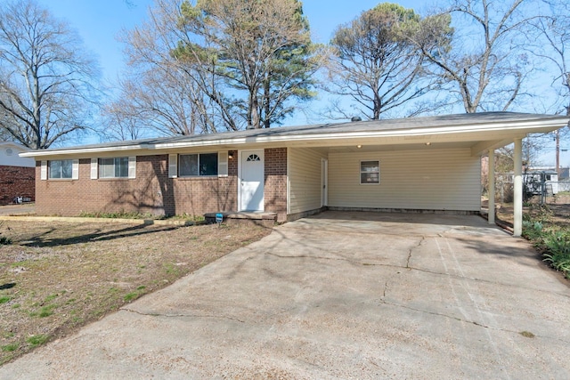 single story home featuring a carport, concrete driveway, and brick siding