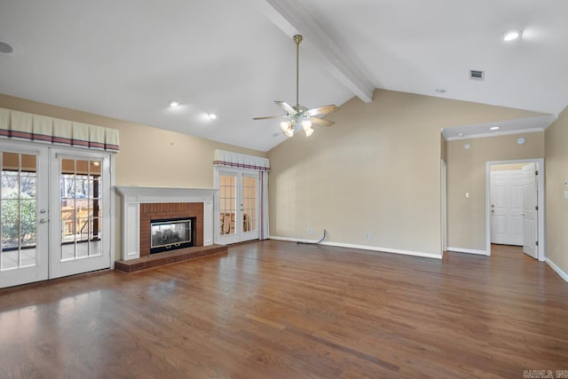 unfurnished living room featuring french doors, lofted ceiling with beams, a brick fireplace, wood finished floors, and baseboards