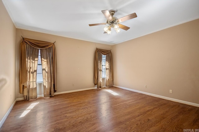 unfurnished room with crown molding, baseboards, and wood finished floors