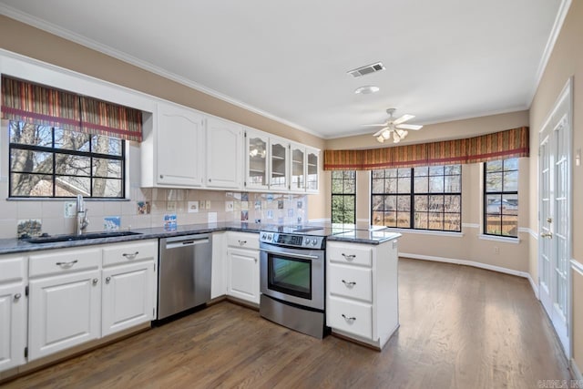 kitchen with stainless steel appliances, dark wood finished floors, a sink, and visible vents