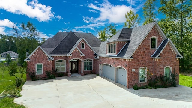 view of front of house with a garage, concrete driveway, and brick siding