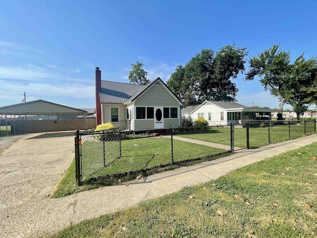 view of front of home featuring a chimney, metal roof, a fenced front yard, and a front yard