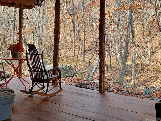 wooden terrace featuring a wooded view