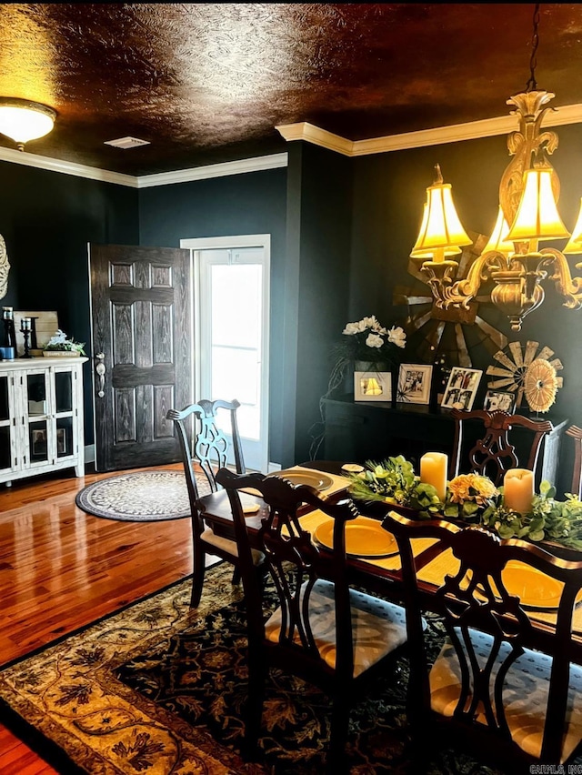 dining area featuring crown molding, a textured ceiling, and wood finished floors