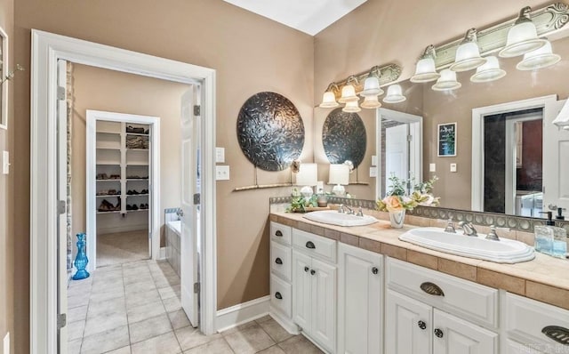 full bath featuring tile patterned flooring, a sink, baseboards, and double vanity