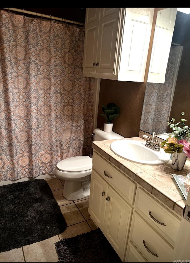 bathroom featuring tile patterned flooring, a shower with curtain, vanity, and toilet