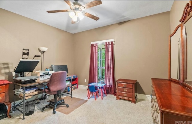 carpeted home office with baseboards and a ceiling fan