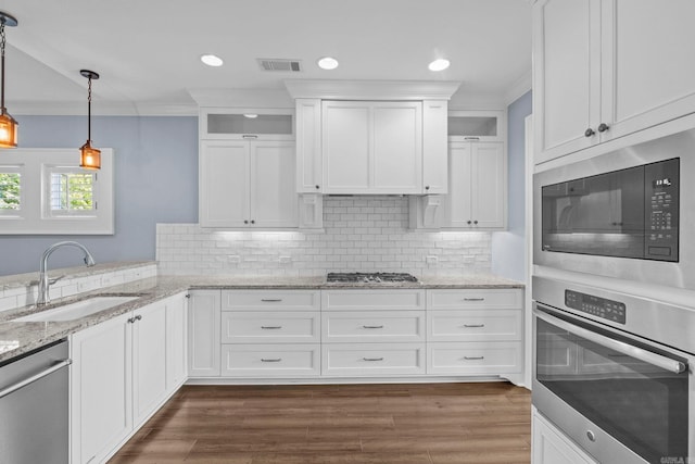 kitchen with crown molding, visible vents, stainless steel appliances, and a sink