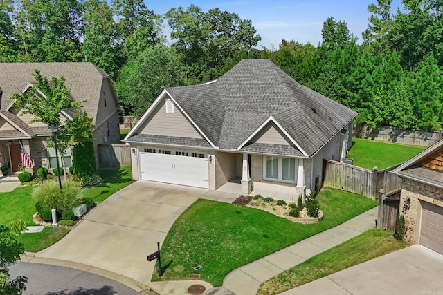 view of front of property featuring a shingled roof, brick siding, fence, and a front lawn