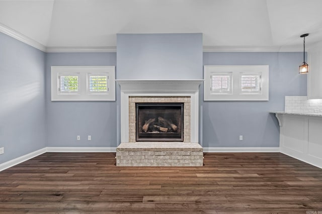 unfurnished living room with baseboards, lofted ceiling, dark wood-type flooring, crown molding, and a fireplace