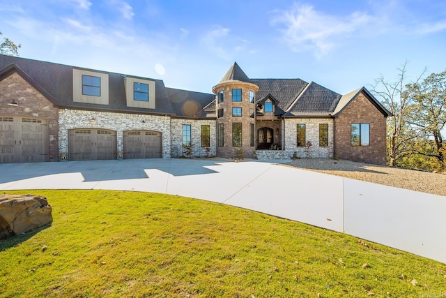 french country style house featuring an attached garage, a front lawn, and concrete driveway