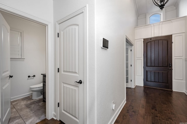 entrance foyer featuring ornamental molding, dark wood finished floors, and baseboards