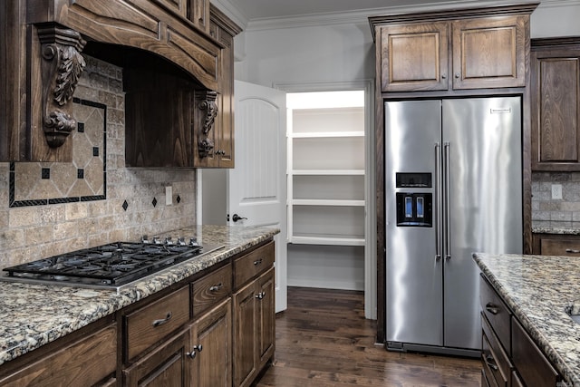 kitchen featuring dark wood-type flooring, appliances with stainless steel finishes, light stone countertops, tasteful backsplash, and crown molding