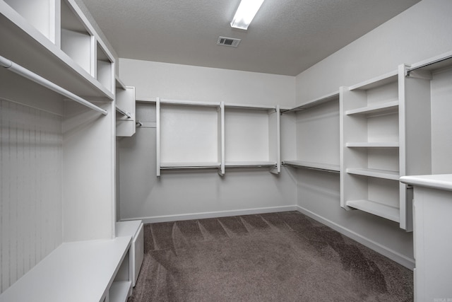 walk in closet with dark colored carpet and visible vents