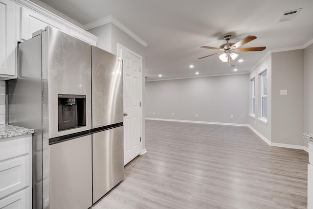 kitchen featuring ornamental molding, stainless steel fridge, visible vents, and white cabinets