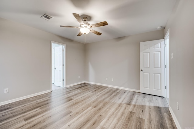 spare room with visible vents, a ceiling fan, light wood-style flooring, and baseboards