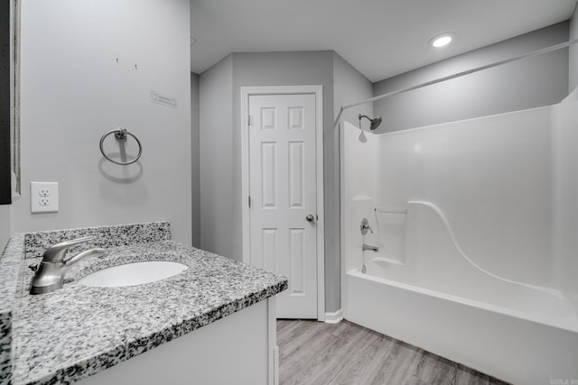 full bath with bathtub / shower combination, vanity, and wood finished floors