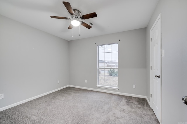 carpeted empty room featuring baseboards, visible vents, and ceiling fan