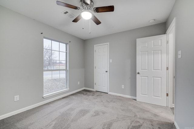 unfurnished bedroom with a ceiling fan, baseboards, visible vents, and carpet flooring