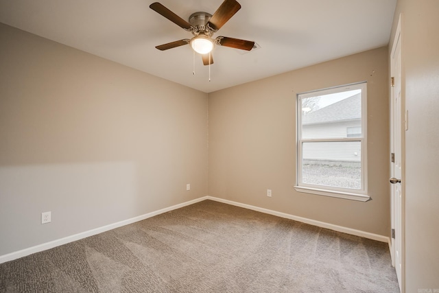 carpeted empty room with baseboards and a ceiling fan