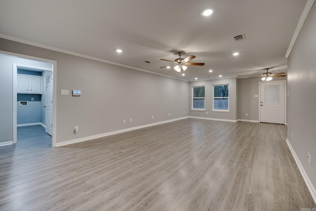 empty room featuring ornamental molding, visible vents, and light wood finished floors