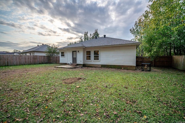 back of property with a yard and a fenced backyard