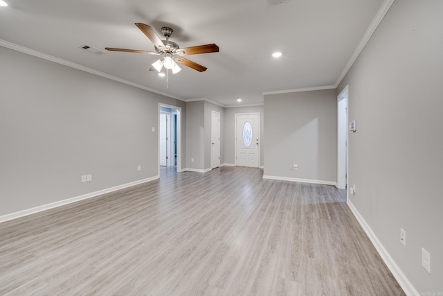 unfurnished living room with crown molding, wood finished floors, visible vents, and baseboards